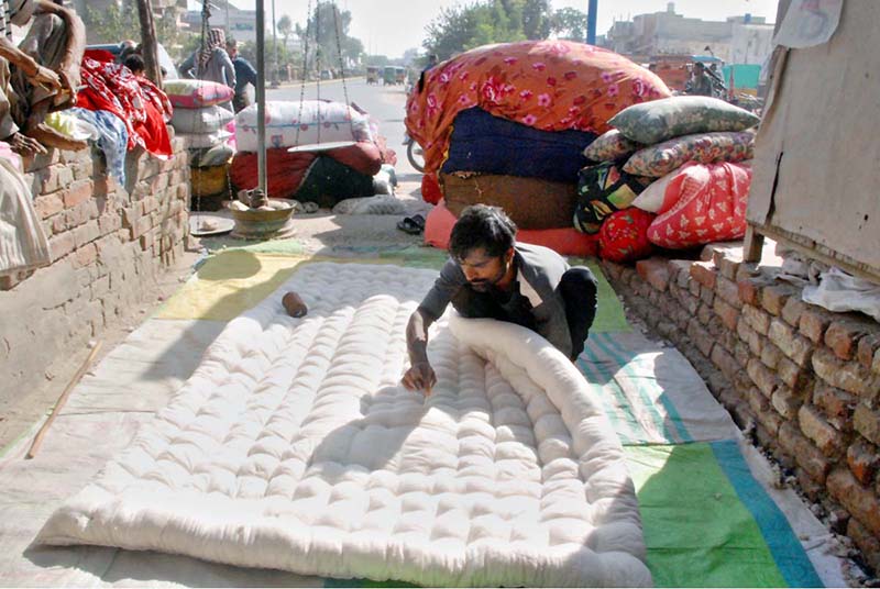 A worker is stitching a traditional local blanket at his workplace