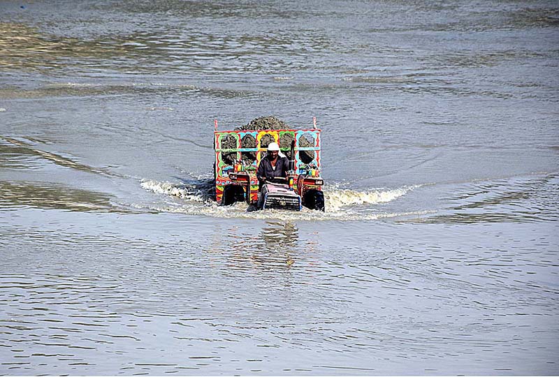 A tractor trolley loaded with sand passing through Rice Canal