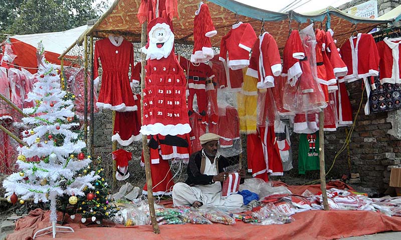 A vendor is displaying and selling Santa Claus outfits for the Christmas festival at G-7/2