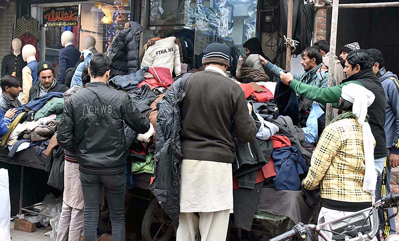 People buying winter clothes from a roadside vendor