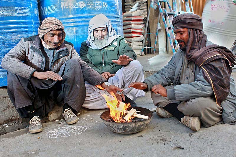 Shopkeepers torching wood in winter to protect from cold breeze