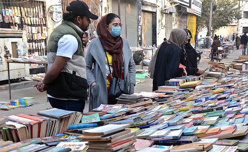 Women selecting old books on a roadside stall at Provincial Capital.