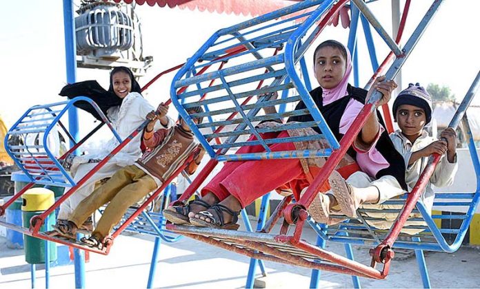 Children enjoying swing at a local park near Otha Chowk