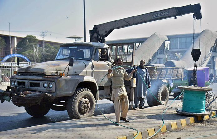 Workers busy in laying wire at Feroze Pur Road