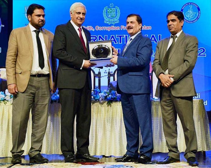 Director General NAB Rawalpindi Mr. Farman Ullah presenting a souvenir shield to Advisor Accountability Irfan Qadir at a ceremony to mark International Anti Corruption Day