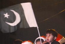 A child waving Pakistani flag in Pakistan Christmas Peace Rally