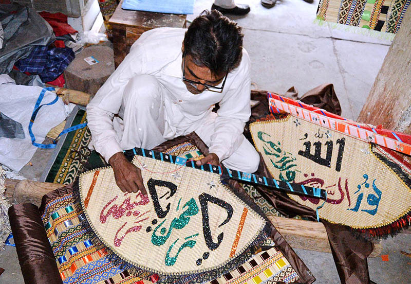 An artisan is showing his artistic skills on hand fans