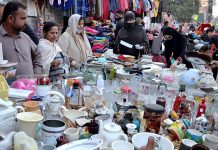 Ladies selecting and purchasing household commodities to the roadside vendor