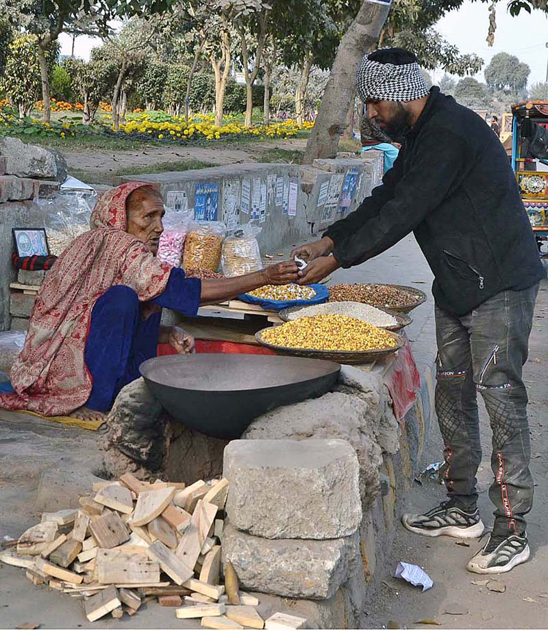 An elderly woman selling grams to a customer at a roadside stop