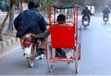 A motorcyclist is helping a disabled person to reach his destination