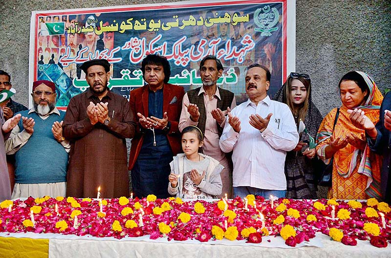 Members of Sohni Dharti Youth Council members offering Dua after lit the candles in commemoration of martyrs of Army Public School Peshawar outside Press Club