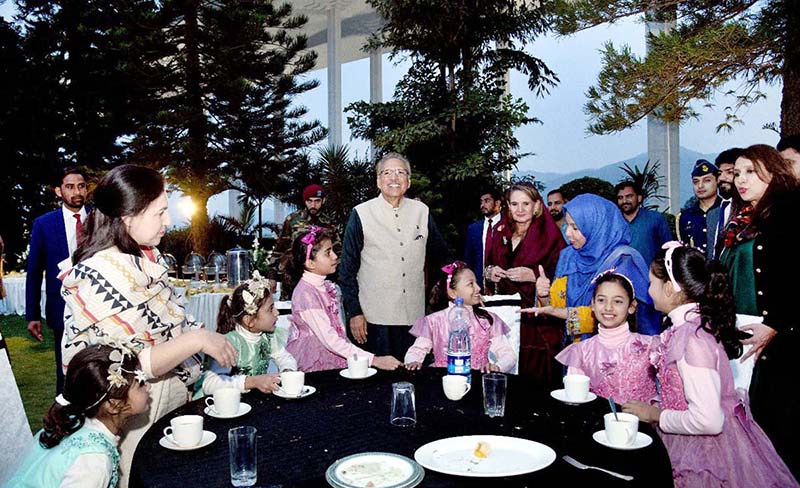 President Dr Arif Alvi serving food to a differently-able children at a ceremony in connection with International Day of Persons with Disabilities at Aiwan-e-Sadr.