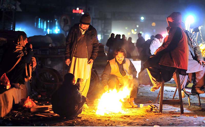 Vendors getting themselves warm during chilled weather along Siri Nagar Road Bhara Kaho