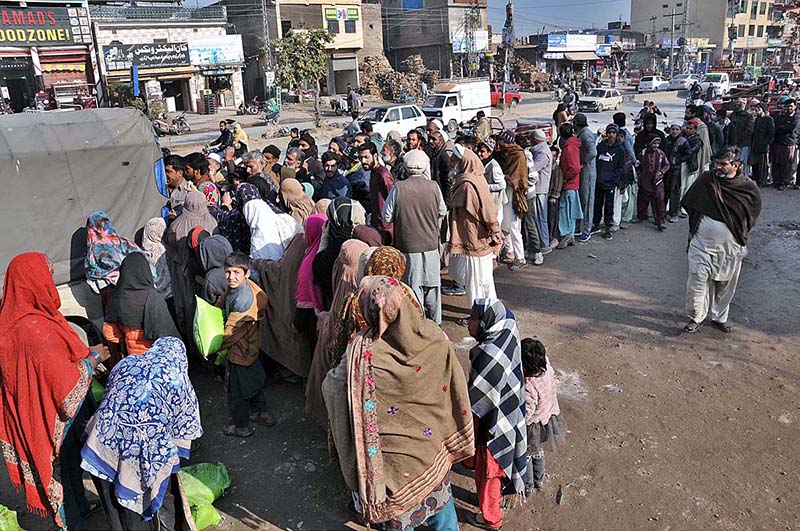 People standing in long queue to purchase wheat flour bags on subsidized rate at Lehtrar Road