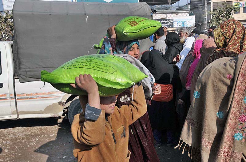 People standing in long queue to purchase wheat flour bags on subsidized rate at Lehtrar Road