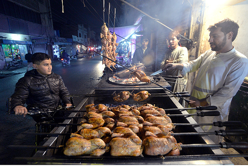 A vendor is preparing a bowl of traditional food item (Dodh Jalebi) during chilled weather for customers at his shop