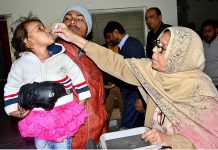 Woman health worker administering polio drops to child at Bhitai Hospital during the Polio Campaign in the city
