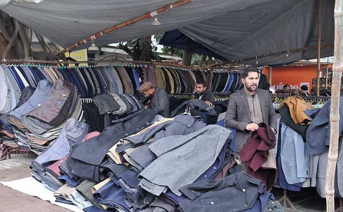 People selecting and purchasing second hand clothes at Karachi Company