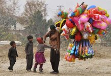 A street vendor displaying different kinds of colorful balloons to attract customers at roadside