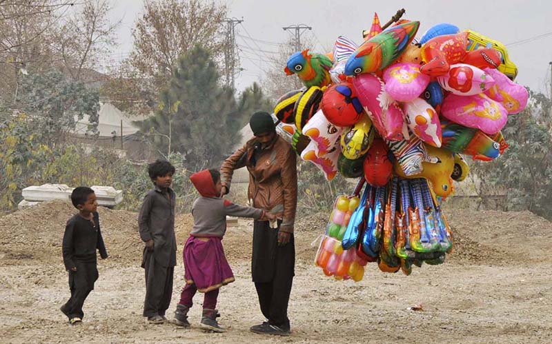 A street vendor displaying different kinds of colorful balloons to attract customers at roadside