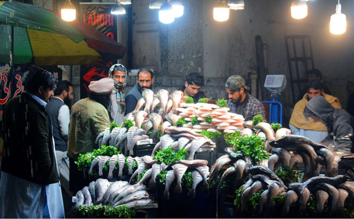 A vendor selling fish to his customers at Melody Food Street