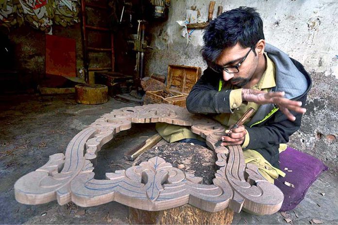 Carpenter busy in making designs on wood at his workplace