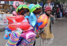 A young street vendor selling colorful balloons at G-9 Markaz