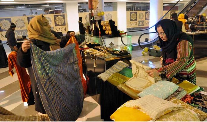 A women displaying shawls and jewelry on his stall during Exhibition at local mall.