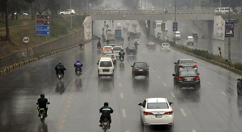 Vehicles on the way at Islamabad Expressway during rain that experienced in the Federal Capital