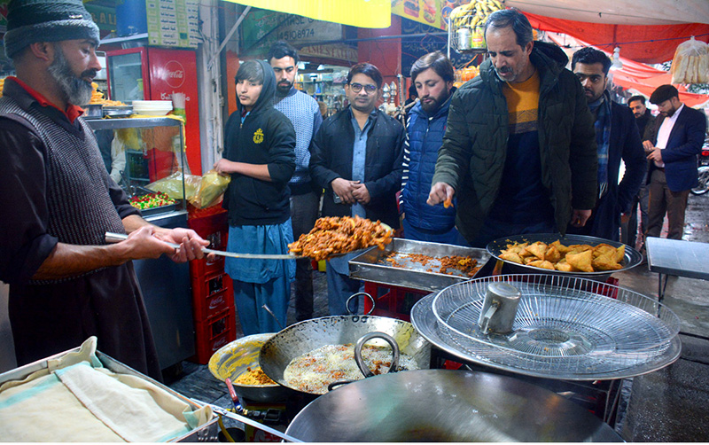 A vendor selling fish to his customers at Melody Food Street