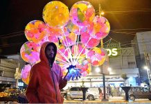 A street vendor displaying the colorful balloons to attract the customers at Latifabad