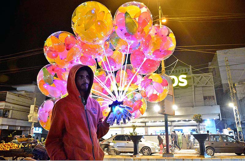 A street vendor displaying the colorful balloons to attract the customers at Latifabad