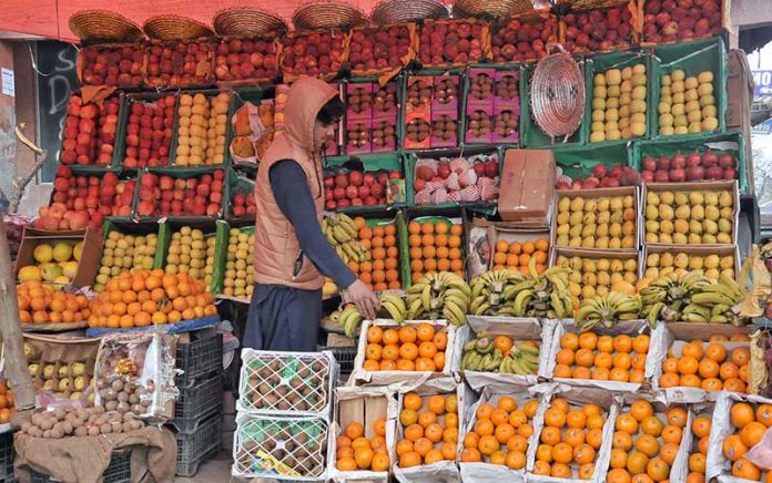 A vendor arranging and displaying different fruits at G-9 Markaz