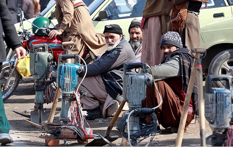 Labourers alongwith their tools sitting on the roadside waiting for clients to be hired for work at Khanna Pul