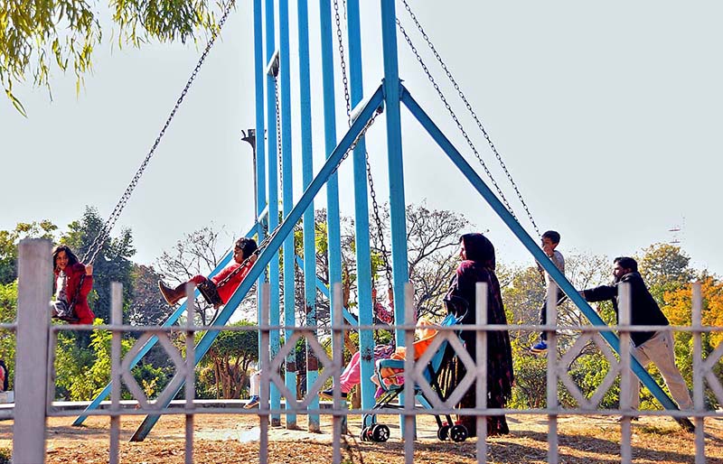 Children enjoying swing in a local park at G-9 in Federal Capital.