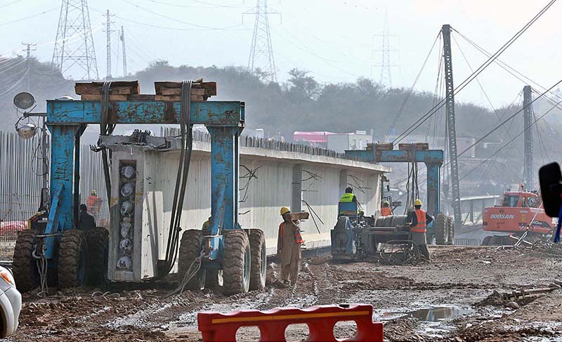 Labourers working at the bridge construction site at Gulberg Green area on Islamabad Expressway