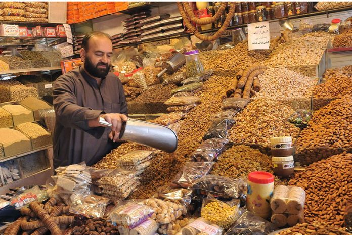 A shopkeeper selling dry fruit and snacks at Aabpara market in Federal Capital