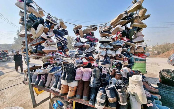 A vendor displaying second hand shoes to attract customers at Saidpur Road