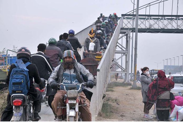 A large number of Motorcyclists crossing from the bridge at Srinagar Highway.