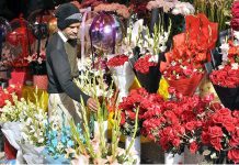 A vendor displaying flower bouquets to attract customers at F-7Flower Market