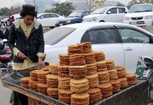A street vendor selling sweet items while shuttling on the road