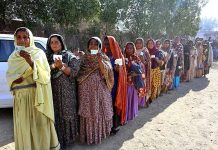 Female voters showing their National Identity Cards while standing in queue at polling station to cast their votes for Local Government Election