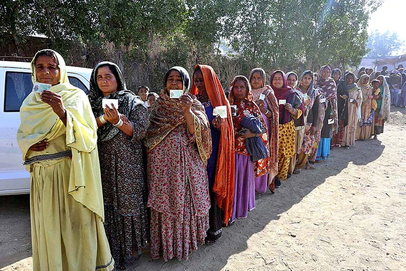 Female voters showing their National Identity Cards while standing in queue at polling station to cast their votes for Local Government Election