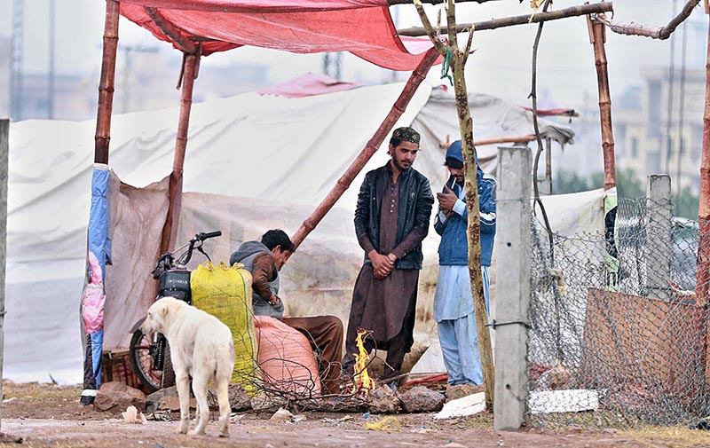 People standing by the fire during rain