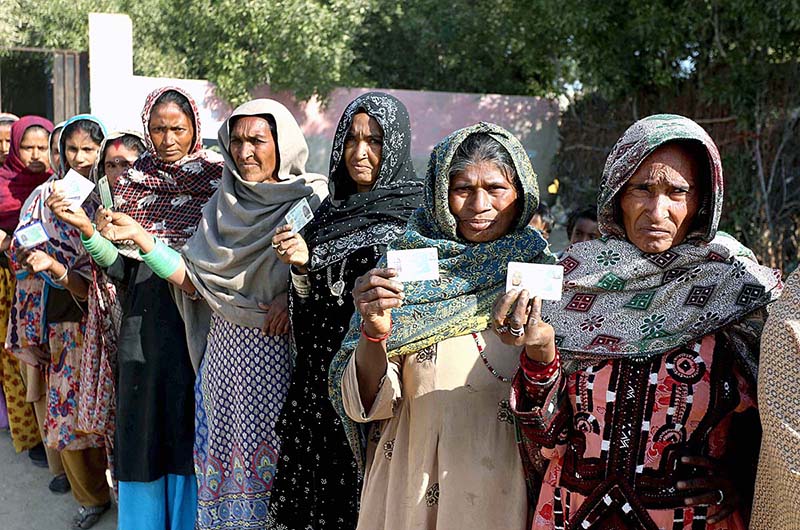 Female voters showing their National Identity Cards while standing in queue at polling station to cast their votes for Local Government Election