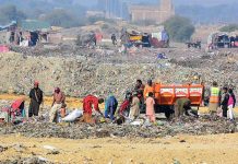 Gypsy peoples searching valuable items from garbage at a landfill site in Latifabad area