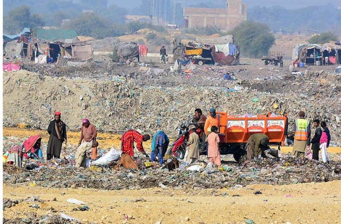Gypsy peoples searching valuable items from garbage at a landfill site in Latifabad area