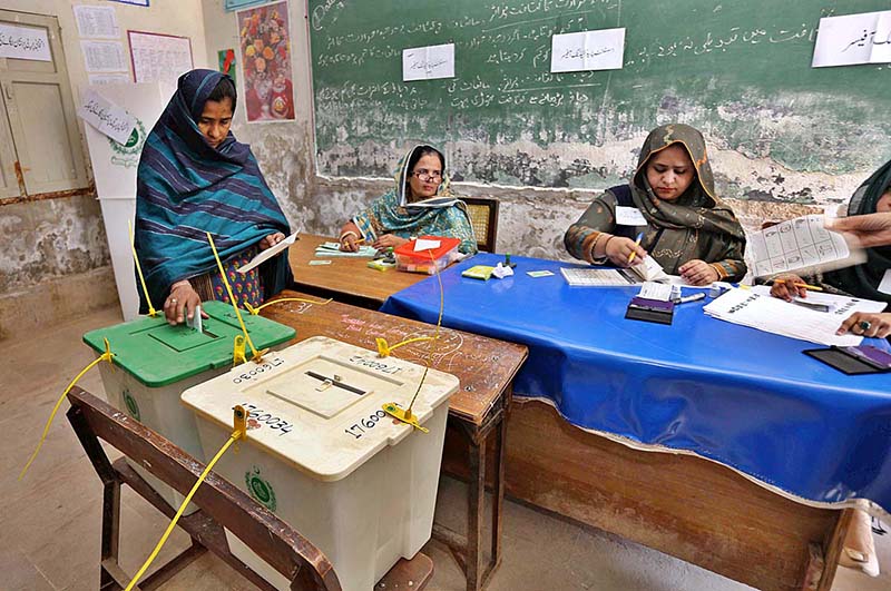 Female voters showing their National Identity Cards while standing in queue at polling station to cast their votes for Local Government Election