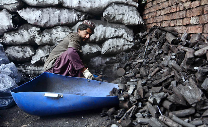 A vendor selling coal at his roadside setup.