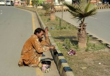 A painter is painting sidelines of a road during maintenance work in the city